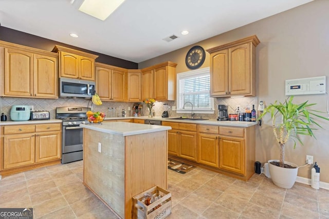 kitchen featuring sink, backsplash, a center island, and appliances with stainless steel finishes