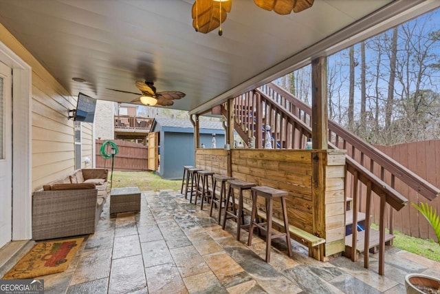 view of patio featuring outdoor lounge area, ceiling fan, and exterior bar