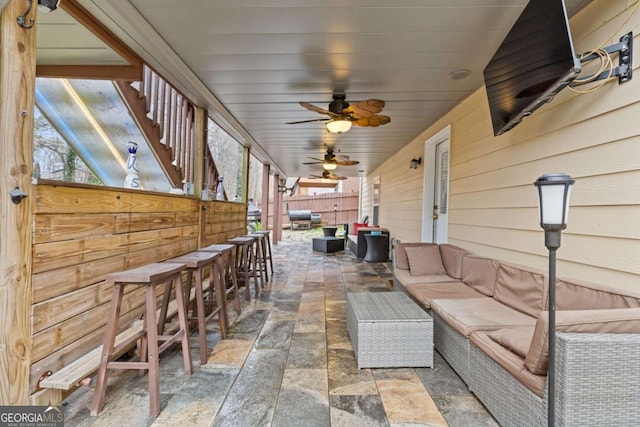 view of patio featuring an outdoor hangout area, ceiling fan, and exterior bar