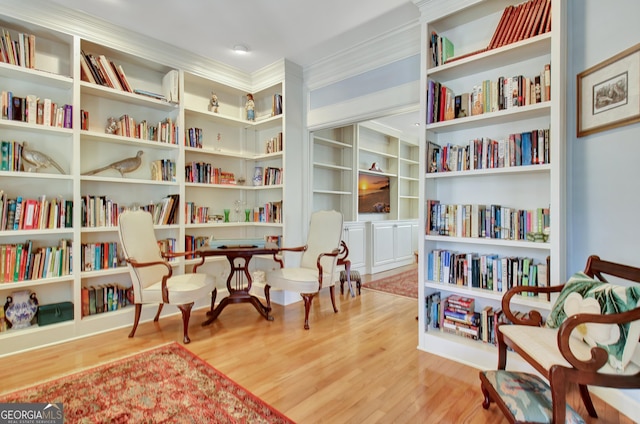 living area featuring hardwood / wood-style floors and ornamental molding