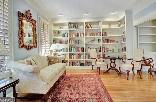 sitting room with hardwood / wood-style flooring and ornamental molding