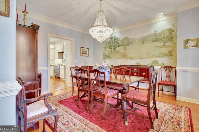 dining room with an inviting chandelier, ornamental molding, and light hardwood / wood-style floors