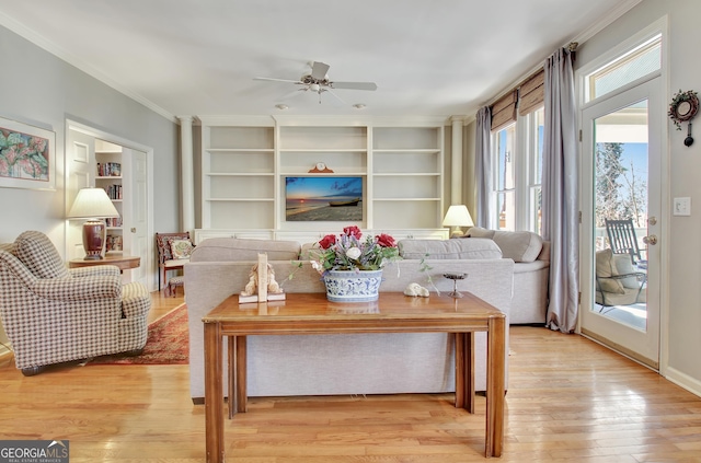 living room with crown molding, ceiling fan, and light hardwood / wood-style flooring