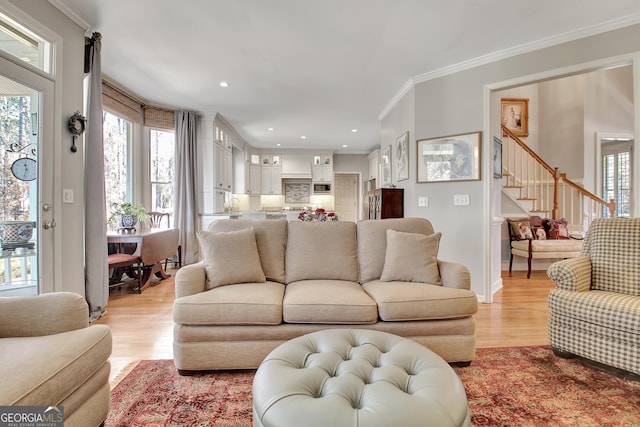 living room with ornamental molding and light hardwood / wood-style flooring