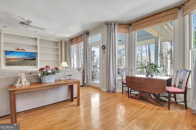 interior space featuring built in shelves, light hardwood / wood-style flooring, and ceiling fan