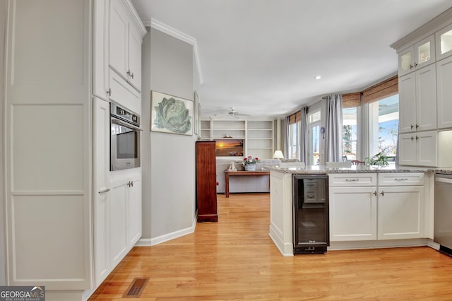 kitchen featuring wine cooler, white cabinetry, stainless steel appliances, and light wood-type flooring