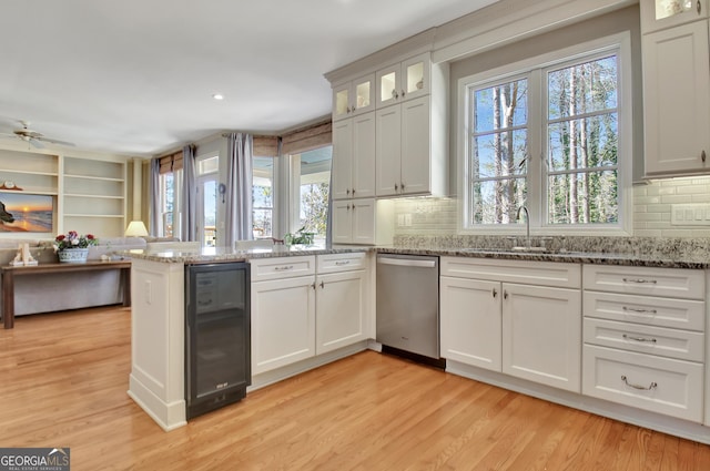 kitchen featuring wine cooler, white cabinetry, light stone counters, dishwasher, and kitchen peninsula