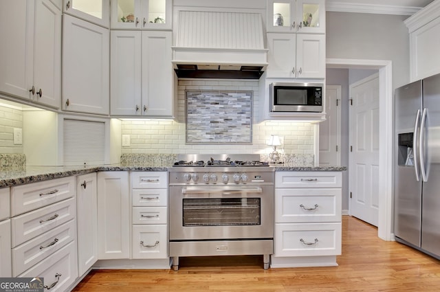 kitchen featuring white cabinetry, custom exhaust hood, and appliances with stainless steel finishes