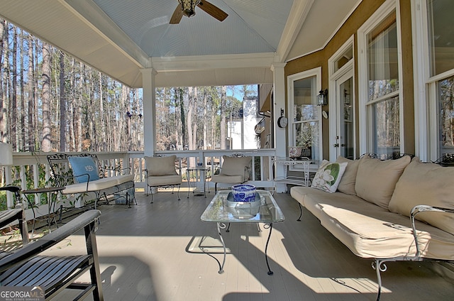 sunroom / solarium with ceiling fan and vaulted ceiling