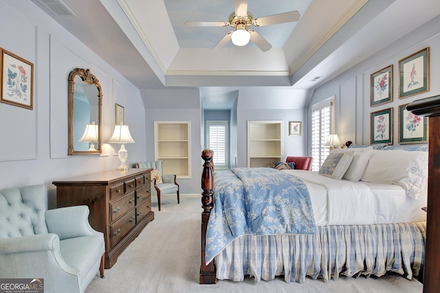 carpeted bedroom with a raised ceiling, ornamental molding, and ceiling fan