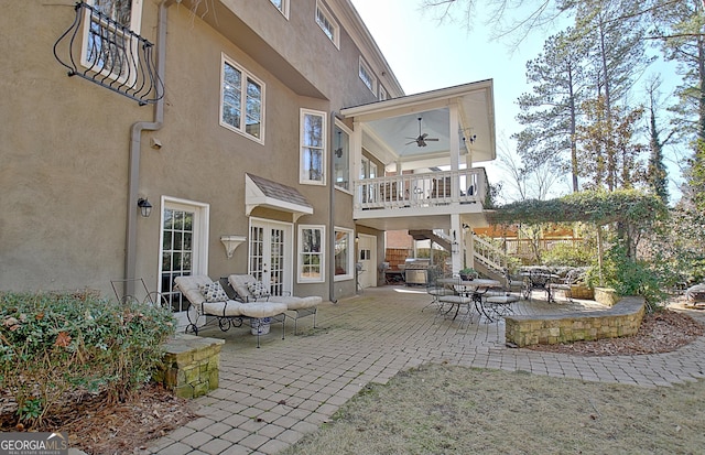 back of property featuring a patio, a balcony, ceiling fan, and french doors