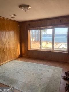 unfurnished room with crown molding and wood walls