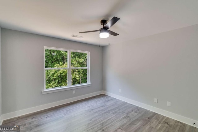 empty room with ceiling fan and light hardwood / wood-style flooring