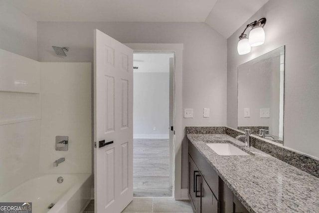 bathroom featuring vanity, lofted ceiling, and shower / bathtub combination