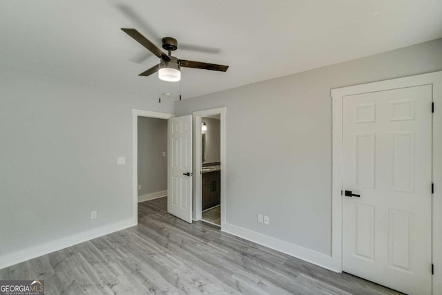 unfurnished bedroom with ceiling fan, ensuite bath, and light hardwood / wood-style flooring