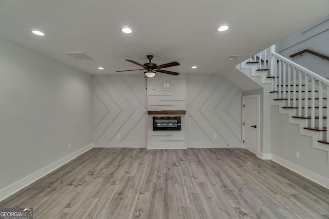 unfurnished living room featuring ceiling fan and light hardwood / wood-style floors