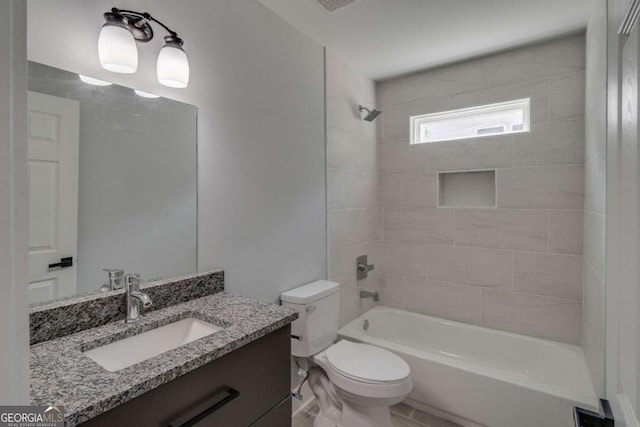 full bathroom with vanity, tiled shower / bath combo, and toilet