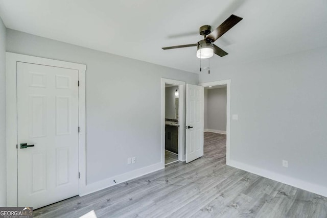 unfurnished bedroom with ensuite bathroom, ceiling fan, and light hardwood / wood-style flooring