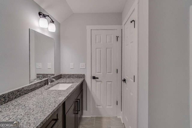 bathroom with vanity and lofted ceiling