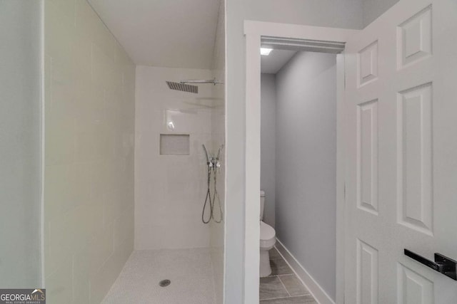 bathroom with tiled shower and toilet