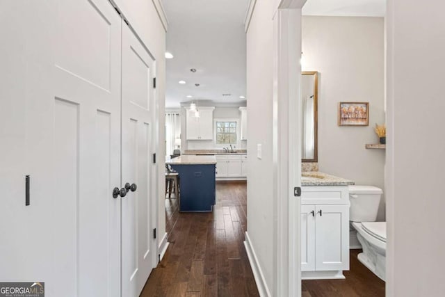 hallway with dark wood-type flooring and sink