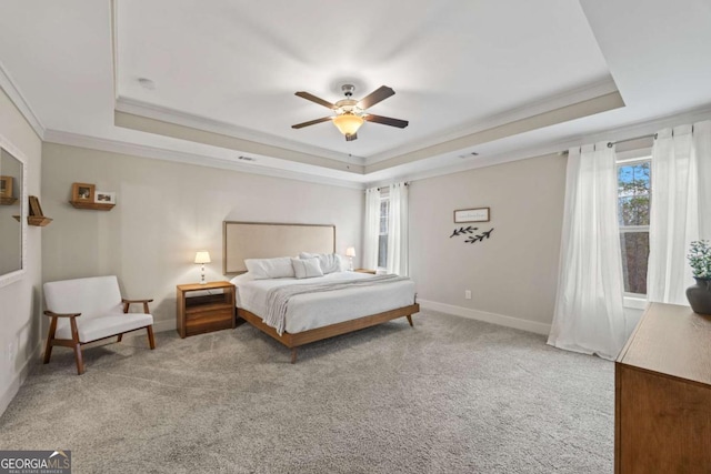 bedroom featuring a raised ceiling, crown molding, carpet flooring, and ceiling fan