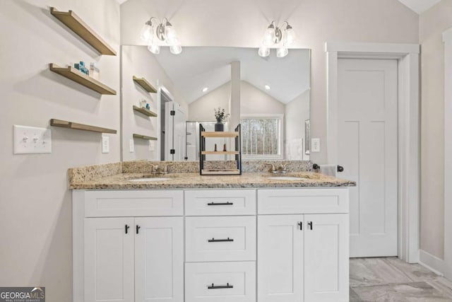 bathroom with lofted ceiling and vanity