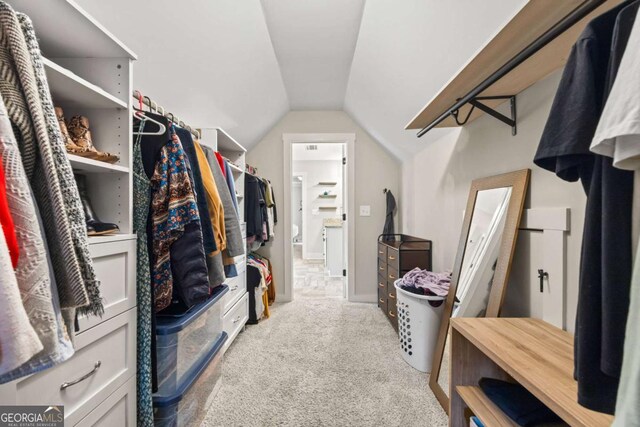 spacious closet with vaulted ceiling and carpet floors