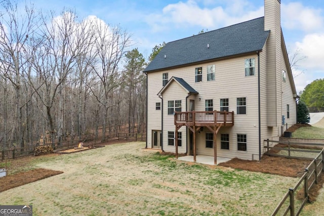 back of house featuring a patio, a yard, and a wooden deck