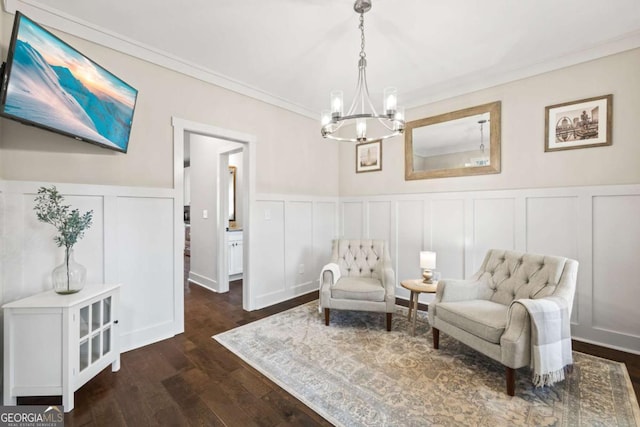 living area with ornamental molding, dark hardwood / wood-style flooring, and a notable chandelier