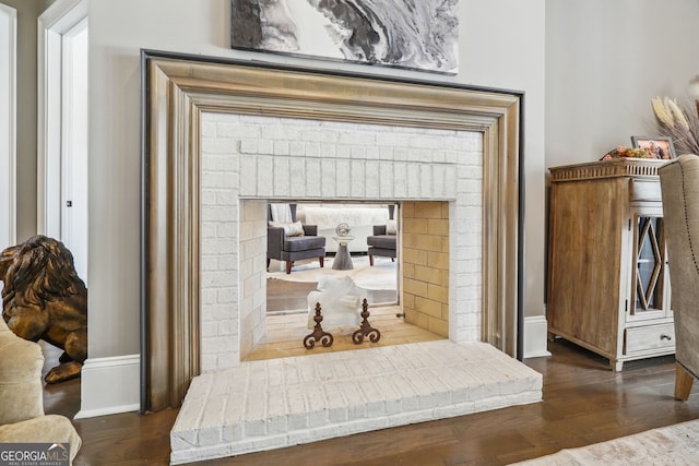 room details with a brick fireplace, baseboards, and wood finished floors