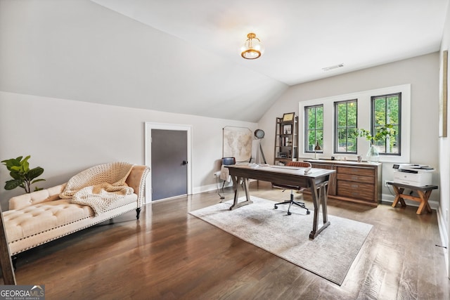 office space featuring baseboards, visible vents, vaulted ceiling, and wood finished floors