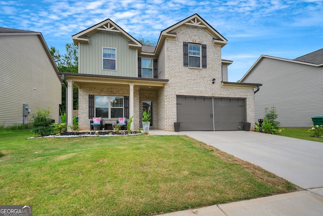 view of front of house featuring a garage, a front yard, and covered porch