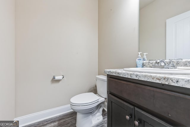 bathroom with vanity, toilet, and hardwood / wood-style floors