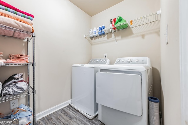 clothes washing area featuring washing machine and dryer and hardwood / wood-style floors