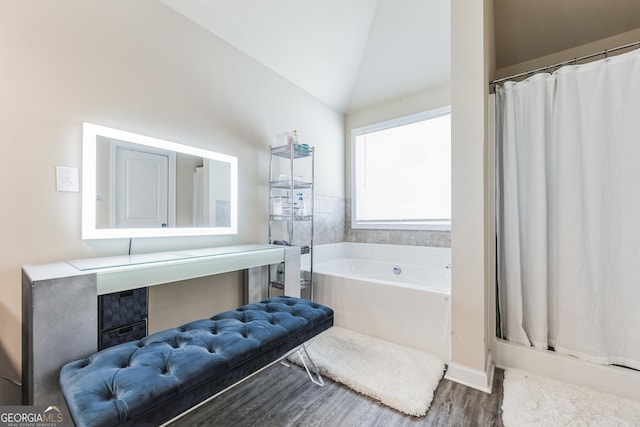 bathroom featuring a bath, vaulted ceiling, and wood-type flooring