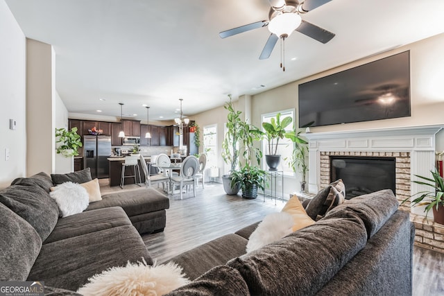 living room featuring a fireplace, dark hardwood / wood-style floors, and ceiling fan