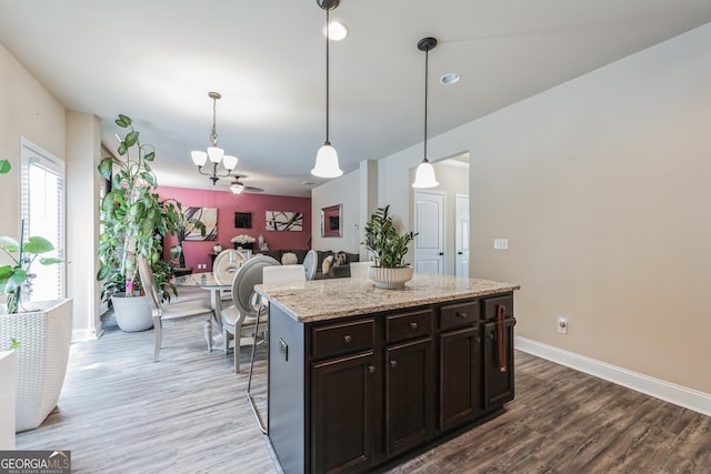 kitchen featuring hardwood / wood-style flooring, a kitchen island, pendant lighting, and dark brown cabinetry