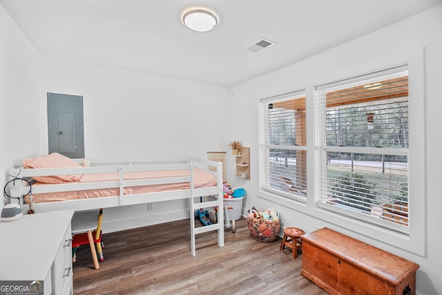 bedroom with wood-type flooring and electric panel