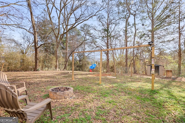 view of yard featuring a fire pit and an outdoor structure