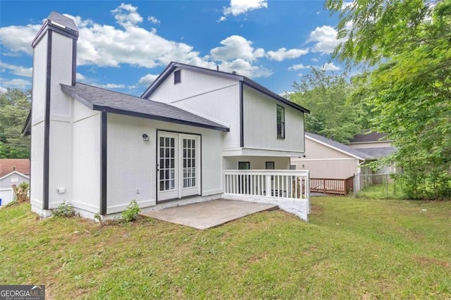 rear view of house with a yard, a patio area, and french doors