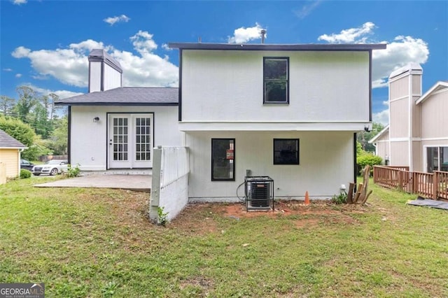 rear view of house with french doors, a yard, a patio area, and cooling unit