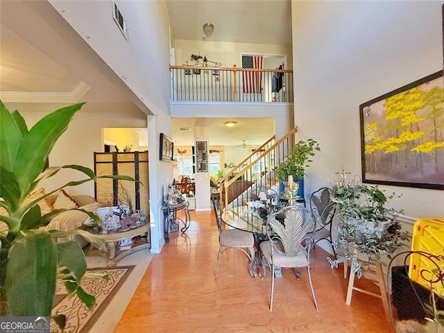 foyer featuring a high ceiling, crown molding, and hardwood / wood-style floors