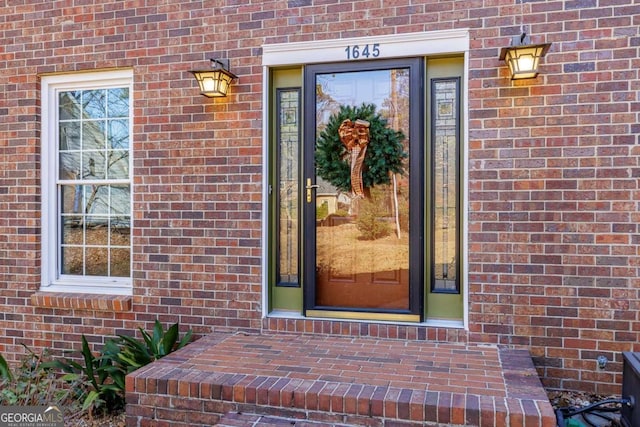 property entrance featuring brick siding