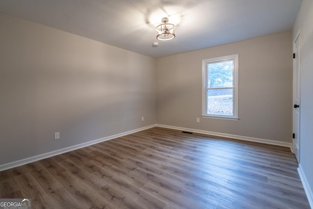 unfurnished room with hardwood / wood-style flooring