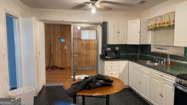 kitchen featuring white cabinetry, sink, gas stove, and ceiling fan