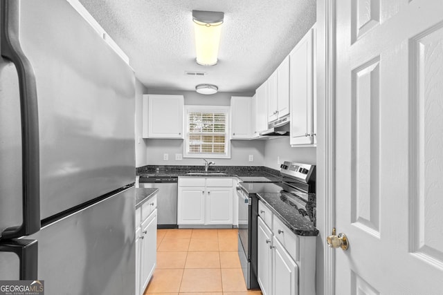 kitchen with sink, white cabinetry, stainless steel appliances, a textured ceiling, and light tile patterned flooring