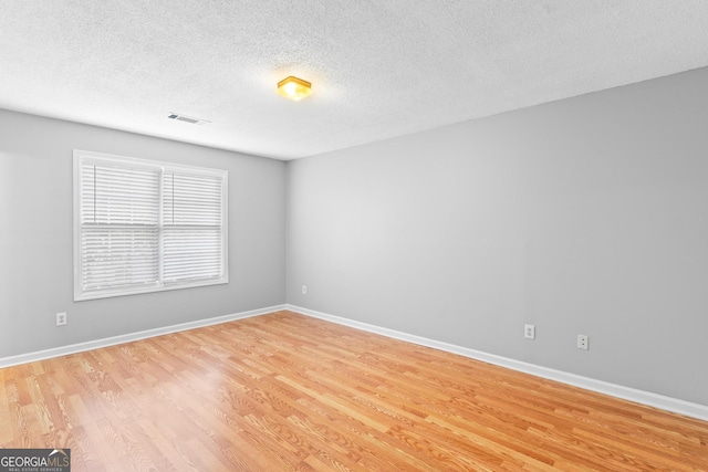 empty room featuring light hardwood / wood-style flooring and a textured ceiling