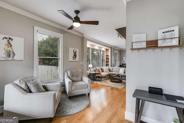 living room with crown molding, track lighting, light hardwood / wood-style floors, and ceiling fan