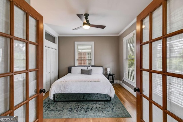 bedroom with french doors, crown molding, and light hardwood / wood-style flooring